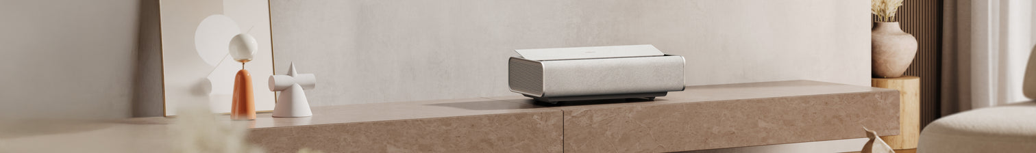 a rectangular white speaker on a stone surface